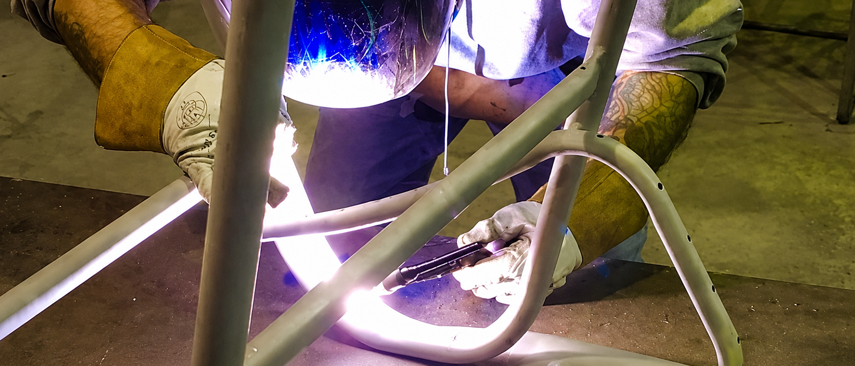 Welding repairs being performed on a pool furniture frame